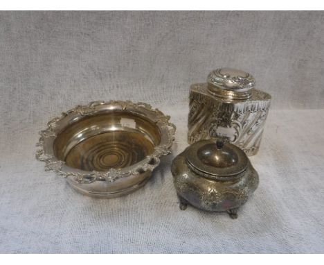 A SILVER MAPPIN & WEBB BOTTLE STAND, Sheffield 1926, a repousse tea caddy and a similar lidded pot  