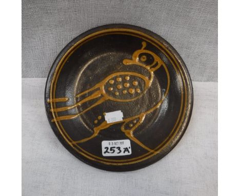 A SLIPWARE DISH DECORATED WITH A BIRD, in the manner of Michael Cardew, 7.5" dia