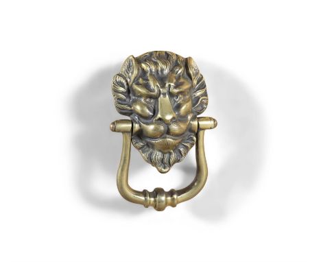 AN EGYPTIAN STYLE CAST BRASS DOOR KNOCKER, in the form of a lion mask with knocker, 18cm high