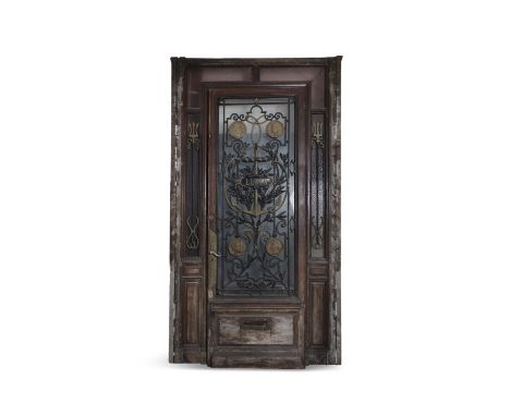 A LARGE HALL DOOR AND FRAME, the door with central glazed panel and cast iron decorated overlay with central anchor motif and