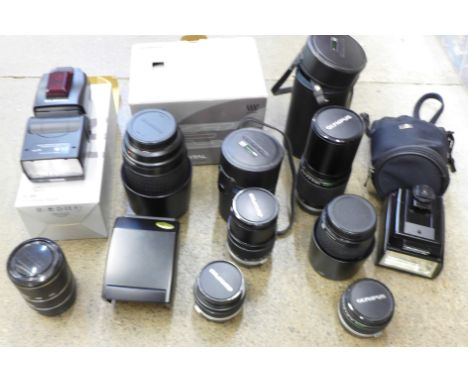 Six Olympus camera lenses including Zuiko digital ED 70-300mm, 200mm F4, 35mm, 28mm, 135mm, a teleconverter, three flash guns