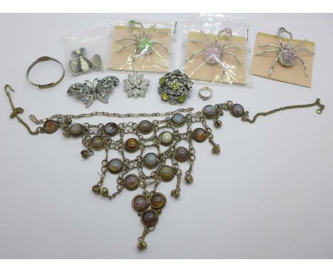 A stone set statement necklace, a small silver bangle, a silver bracelet, three large spider fashion brooches, etc. 