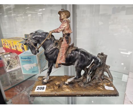 A COLOURED SPELTER COWBOY TABLE LIGHTER