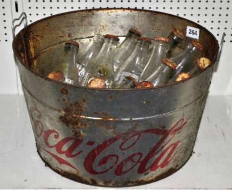 A Coca Cola advertising ice bucket and a quantity of a vintage Coca Cola bottles.