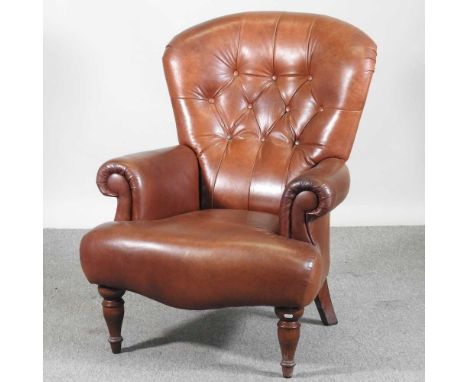 A modern brown leather upholstered button back armchair, on turned legs