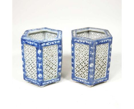 A pair of Chinese porcelain blue and white tea light holders, 20th century, with pierced panels, 13cm high (2)One is cracked 