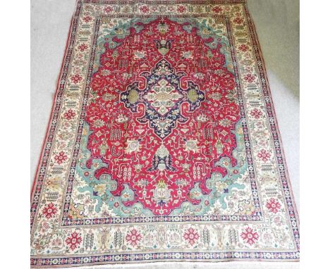 A Persian heriz carpet, with all over foliate designs, on a red field, 347 x 247cm