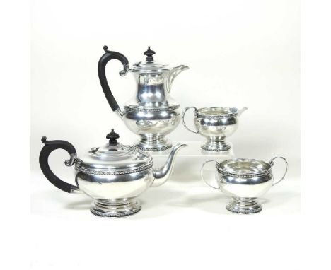 An early 20th century silver four piece tea service, of circular shape, with ebonised handles and finials, by Poston &amp; Co