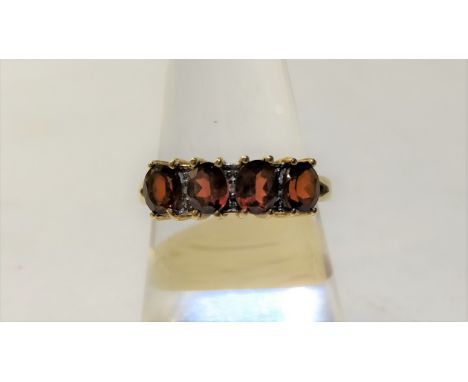 A four stone garnet ring, stamped '9K', with a small single cut diamond between each garnet, one setting vacant, finger size 