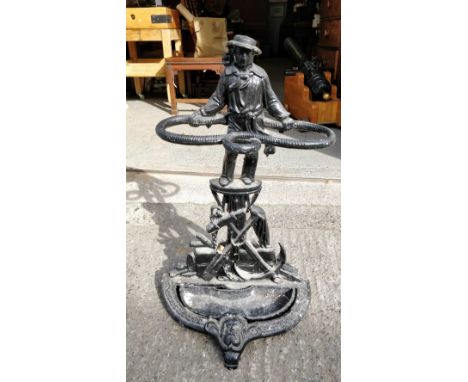 A cast iron stick stand with a standing male holding a rope, 71cm high