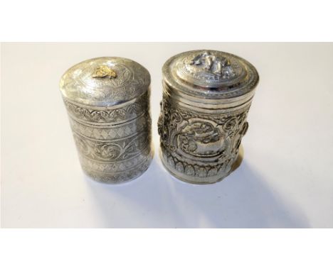 A Burmese tea caddy, with highly embossed decoration, stamped 'Silver' and 'Burma'; and another tea caddy with flat chased de