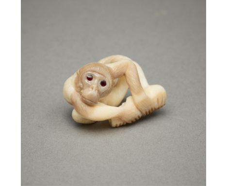 Gregg Stradiotto (American, 20th c). Carved ojime of a monkey. Carved from fossil walrus ivory with amber inlaid eyes.Provena