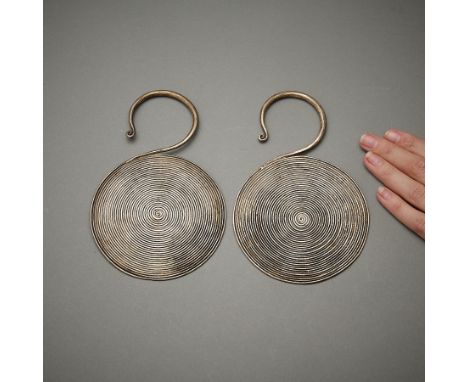 Large earrings comprised of draw wire spiraled into a snake motif (generally associated with fertile soil in this culture), w