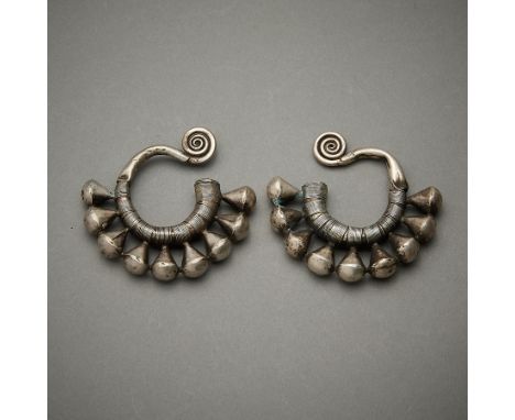 Pair of earrings comprised of a swirled ear loop and wrapped with silver wire, suspending nine conical motifs. From the Dong 