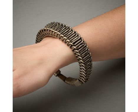 Fine metal bracelet comprised of drawn and twisted silver wire, further twisted into a complex pattern and wrapped at the end