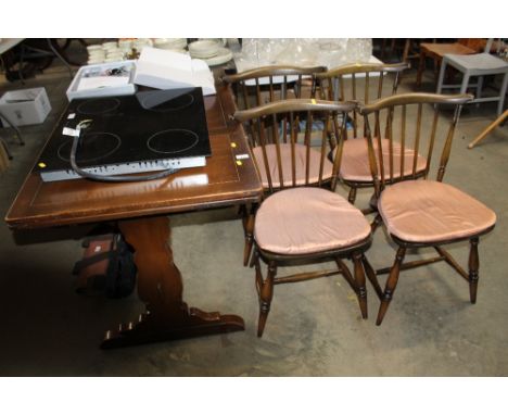 An Ercol extending dining table and a set of four Ercol stick back chairs