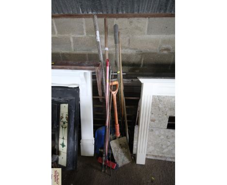 A quantity of long handled garden tools to include brushes, spades, shovels etc.
