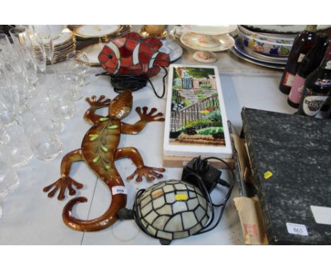 A decorative plaque wall hanging in the form of a gecko, a lamp in the form of a tortoise and a lamp in the form of a fish