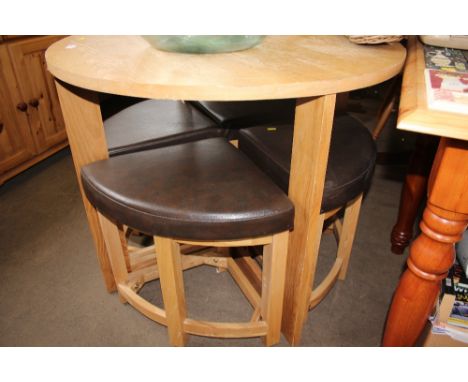 A light oak veneered circular table with a set of four stools