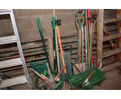 A large quantity of garden tools to include spades; hoe's; bench vice; seed spreader