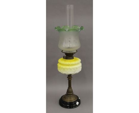 A Victorian oil lamp with yellow glass reservoir. 72 cm high overall.