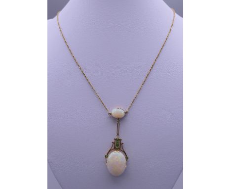 An 18 ct gold opal and emerald set drop pendant necklace. The pendant 5 cm high. 7.7 grammes total weight.