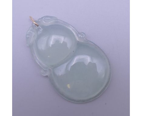 A gold mounted icy jade pendant. 5 cm high.
