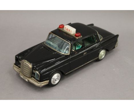 A Japanese tin plate Mercedes taxi, with opening doors and flashing top light. 25.5 cm long. 