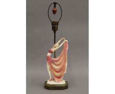 A table lamp mounted with a porcelain Art Deco dancing lady. 55.5 cm high overall.