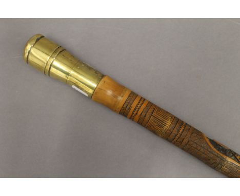 A Japanese carved bamboo walking stick, the brass handle set with a compass. 94.5 cm high.