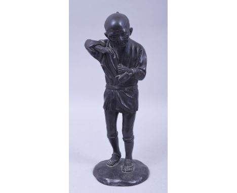 A JAPANESE MEIJI BRONZE FIGURE OF A FARMER HOLDING A PIPE, on a circular bronze base, 29.5cm high.