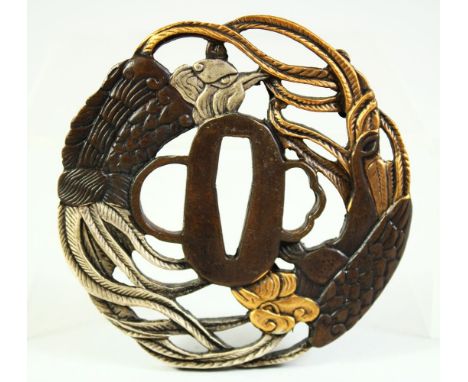 A JAPANESE BRONZE SHAKUDO TSUBA, of pierced design depicting an eagle and phoenix, signed, 8cm diameter.