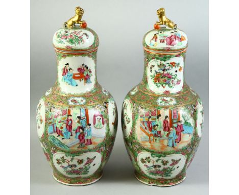 A PAIR OF CHINESE CANTON FAMILLE ROSE PORCELAIN VASES AND COVERS, painted with panels of figures as well as birds, butterflie