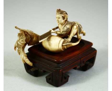 A SMALL JAPANESE CARVED IVORY OKIMONO, of male figure with a giant radish, together with an associated hardwood stand, figure