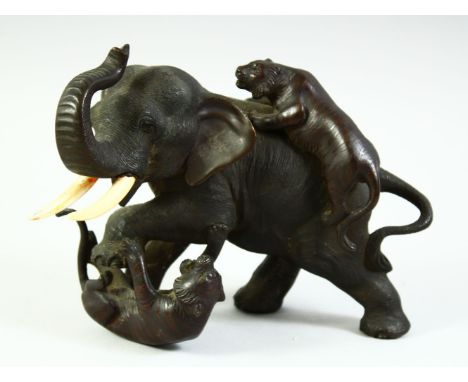 A JAPANESE MEIJI PERIOD BRONZE GROUP OF A BULL ELEPHANT being attached  by two tigers, with impressed seal mark to base, 19cm