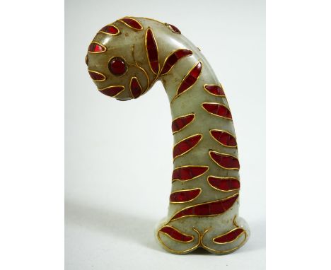 AN INDIAN GREEN HARDSTONE DAGGER HANDLE, onlaid with red stones and wirework decoration, 13cm long.