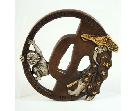 A JAPANESE BRONZE SHAKUDO TSUBA, of unusual form depicting a bearded figure and a demon, signed and inscribed, 8.5cm x 8cm.