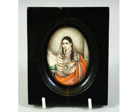 AN INDIAN MINIATURE OVAL PORTRAIT OF A FEMALE FIGURE on ivory, in an ebonised wood frame and glazed, image 7cm x 5cm.