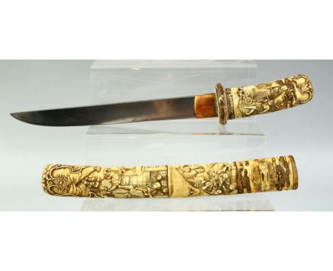 A JAPANESE CARVED IVORY TANTO DAGGER, the scabbard and handle finely carved with village scenes and many figures in various p