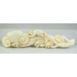 A CHINESE CARVED JADE MODEL OF A MONKEY UPON A RUYI FORMED BRANCH, 15cm long.