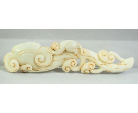 A CHINESE CARVED JADE MODEL OF A MONKEY UPON A RUYI FORMED BRANCH, 15cm long.