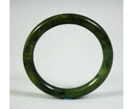 A 19TH CENTURY CHINESE JADE BANGLE, 8cm diameter.