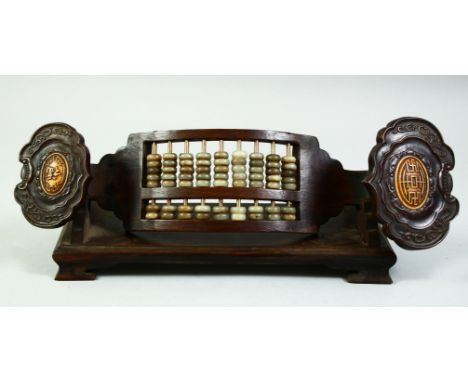 A CHINESE WOODEN ABACUS IN RUYI SCEPTER, with wooden stand, 32cm long.