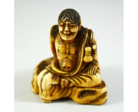 A JAPANESE CARVED IVORY NETSUKE, of a crouching male figure, 5cm high.