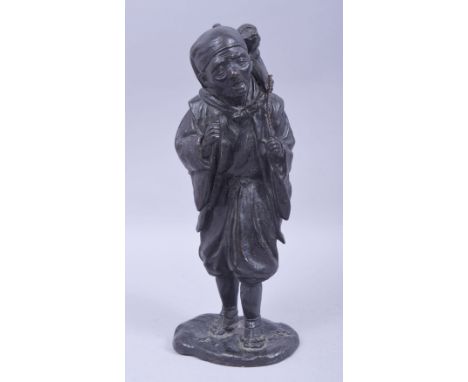 A JAPANESE MEIJI BRONZE FIGURE OF A MAN WITH A MONKEY, the figure standing upon a base with the monkey upon his back, 32cm hi