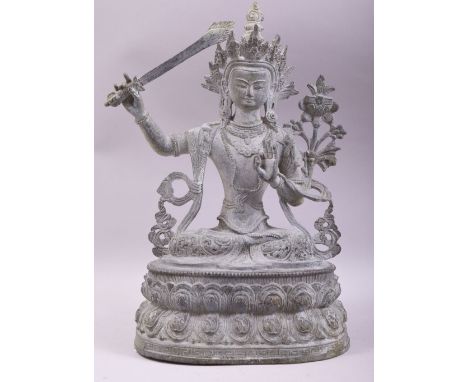 A LARGE BRONZE FIGURE OF A DEITY HOLDING A SWORD, 38cm high.