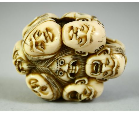 A JAPANESE CARVED IVORY NETSUKE, carved as a roundel of noh masks, 5.5cm.