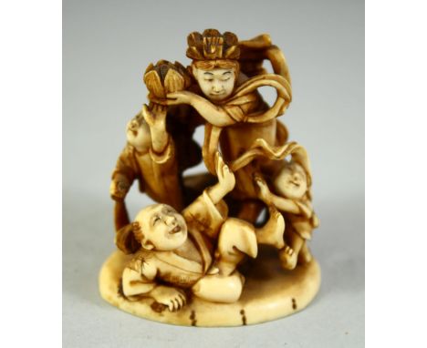 A JAPANESE CARVED IVORY NETSUKE, depicting a playful scene with a male and female figure with children, signed to base, 5.5cm