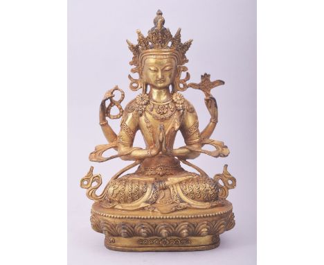 A TIBETAN GILT BRONZE MODEL OF A SEATED DEITY, 28cm high.