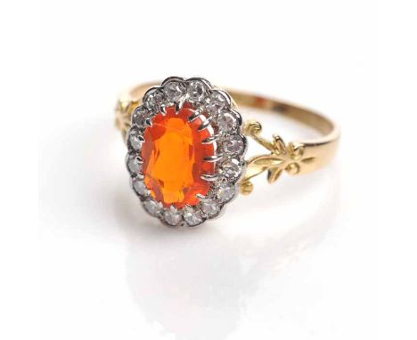 UNUSUAL ORANGE SAPPHIRE AND DIAMOND CLUSTER RING
set with a central oval orange sapphire surrounded by diamonds, on split fol